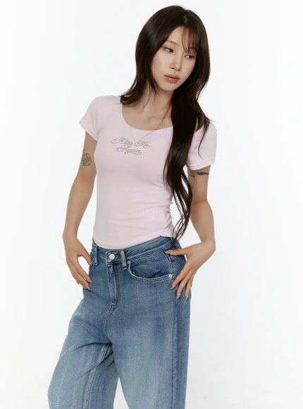 Slim Fit Graphic Tee CL508 Light pink three-quarter front shot on model hands on hips showing rhinestone graphic scoop neck and body-hugging fit with jeans