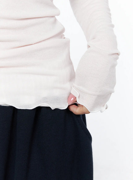 Slim-Fit Henly Neck Long Sleeve Tee IU525 Light pink close-up detail of lettuce ruffle hem and thumbhole cuff on model