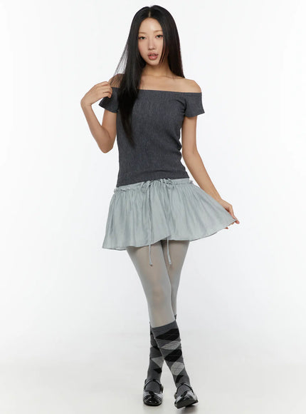 Slim Fit Off-Shoulder Tee CU526 Dark gray full-body front model shot with argyle knee socks and loafers, model lifting skirt hem playfully