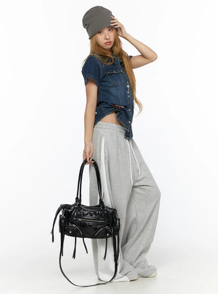 Slim Fit Wrinkle Wash Short Sleeve Jean Shirt CL528 Blue front three-quarter shot on model with grey beanie holding black leather bag styled with grey wide-leg sweatpants