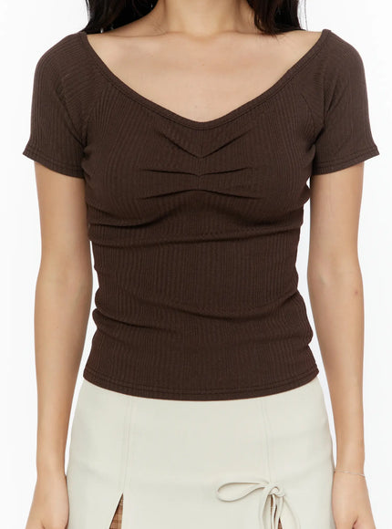Slim Off-Shoulder Top CU526 Brown close-up front detail on model showing ruched v-neckline, ribbed knit texture, and fitted waist with short sleeves