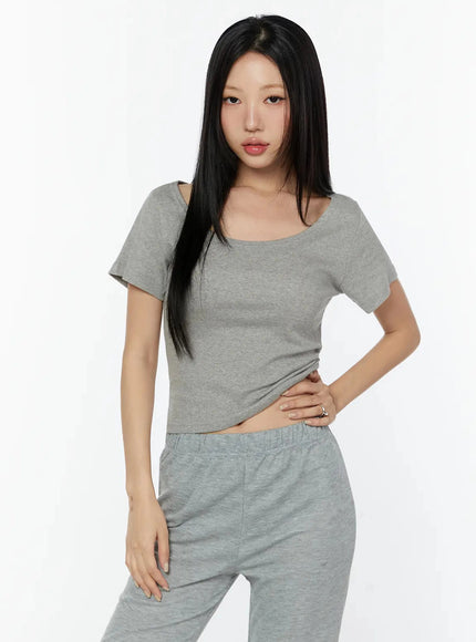 Slim U-Neck Short Sleeve Tee IU524 Gray cropped front shot on model with hand on hip, showcasing fitted crop length and U-neckline, paired with gray sweatpants