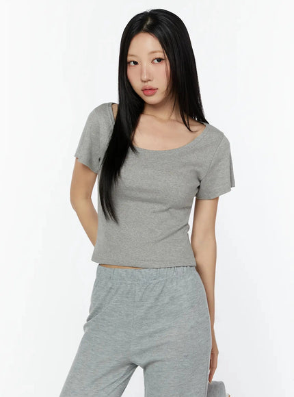 Slim U-Neck Short Sleeve Tee IU524 Gray cropped three-quarter front shot on model with relaxed pose, scoop neckline visible, layered over gray wide-leg pants