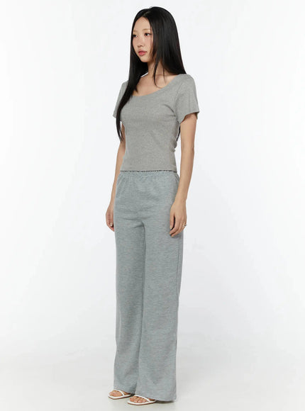 Slim U-Neck Short Sleeve Tee IU524 Gray full-length side shot on model, showing slim cropped silhouette and asymmetric scoop neckline with gray wide-leg pants