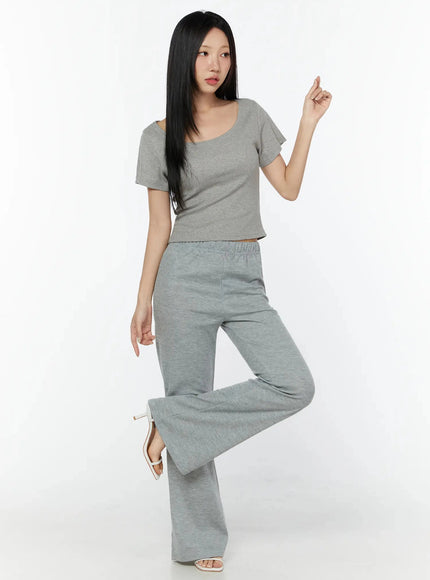 Slim U-Neck Short Sleeve Tee IU524 Gray full-length dynamic pose shot on model with one leg raised, paired with gray wide-leg pants and heeled sandals