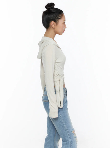 Soft Hooded Wrap Cardigan CL513 Beige side shot on model showing hooded back, wrap tie silhouette, cropped length with lace trim, and long sleeves