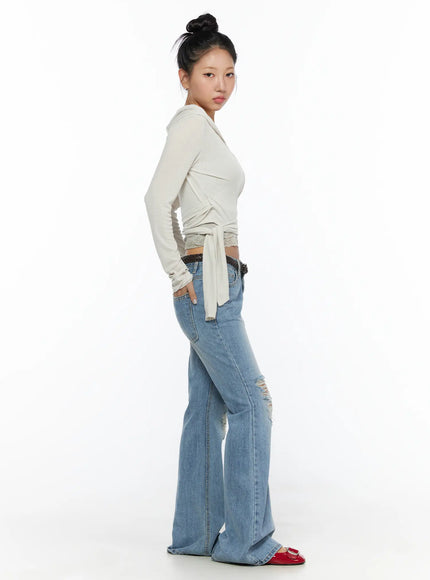 Soft Hooded Wrap Cardigan CL513 Beige side shot on model in full-length view, hooded wrap style with tie detail, lace hem, paired with flare jeans and red shoes