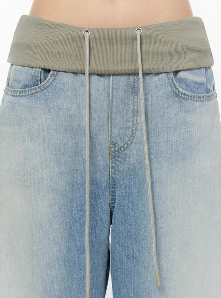 Solene Vintage Washed Foldover Baggy Jeans IU524 Blue close-up front detail of khaki ribbed foldover waistband with silver eyelet drawstring cord and front pockets