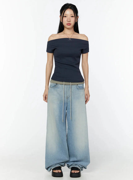 Solene Vintage Washed Foldover Baggy Jeans IU524 Blue full front shot on model facing camera styled with navy off-shoulder top showing full-length baggy wide-leg fit