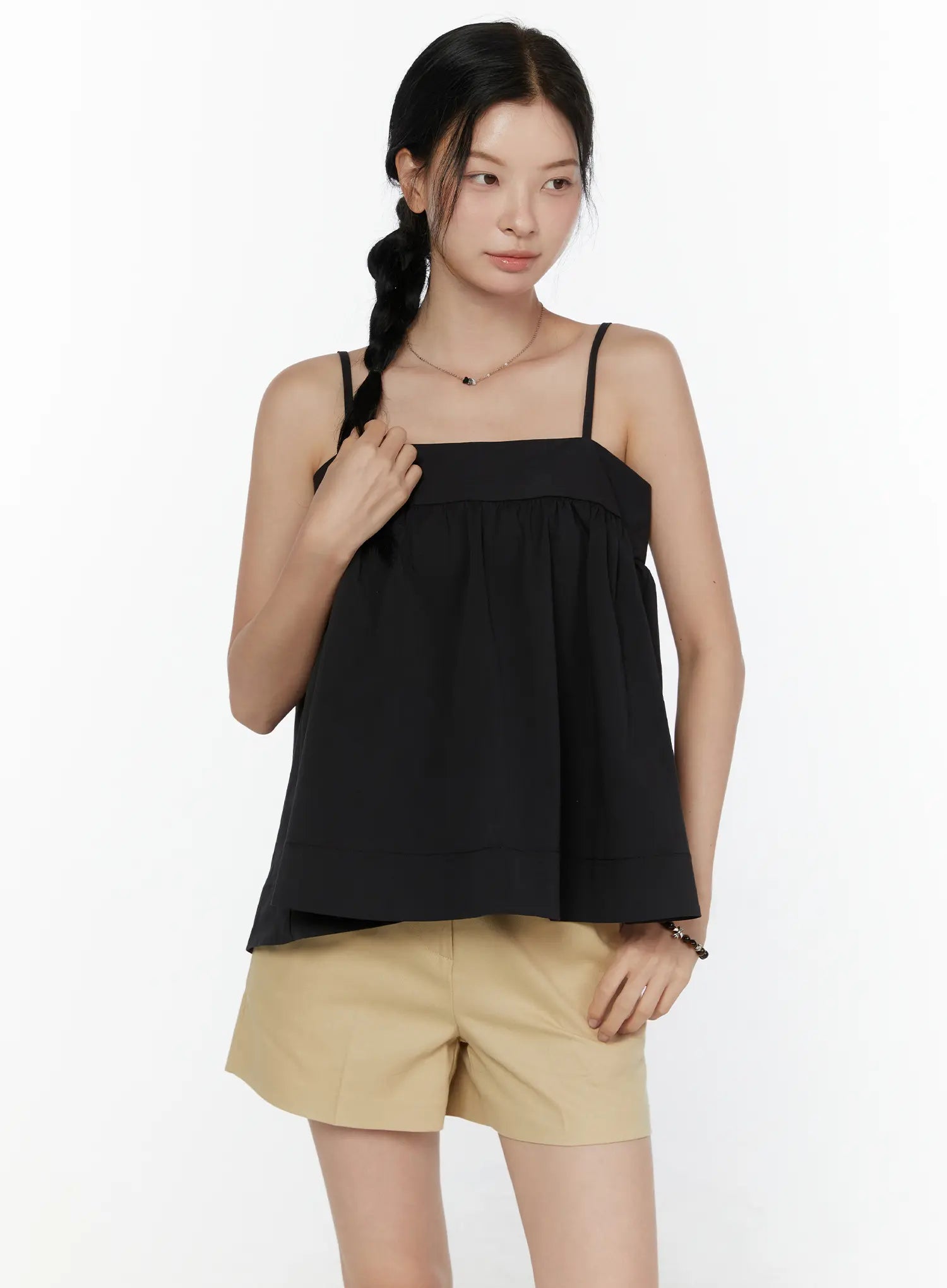 Square Neck Babydoll Cami Top CL520 Black front shot on model with hand raised to strap, styled with beige shorts, relaxed A-line silhouette