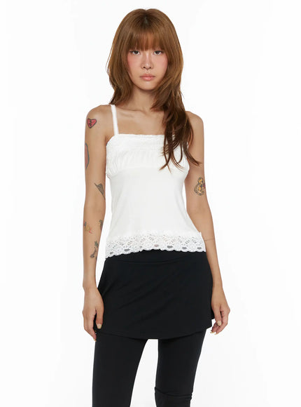 Square Neck Lace Cami CL503 White front view on model standing straight, lace ruched square neckline, floral lace hem, styled with black mini skirt and leggings