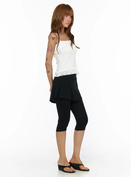 Square Neck Lace Cami CL503 White side view on model standing sideways, lace hem detail and spaghetti straps, paired with black skirt-legging and wedge sandals
