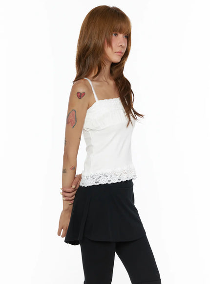 Square Neck Lace Cami CL503 White side view on model, ruched bust and floral lace hem, worn under open teal shirt with black mini skirt and leggings styling