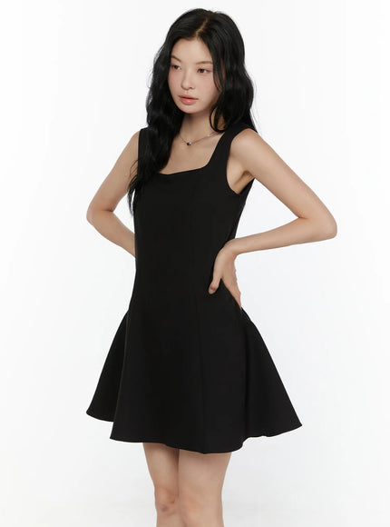 Square Neck Mini Dress CL521 Black side-angle full-body shot on model with hand on hip showing A-line silhouette and smooth fabric