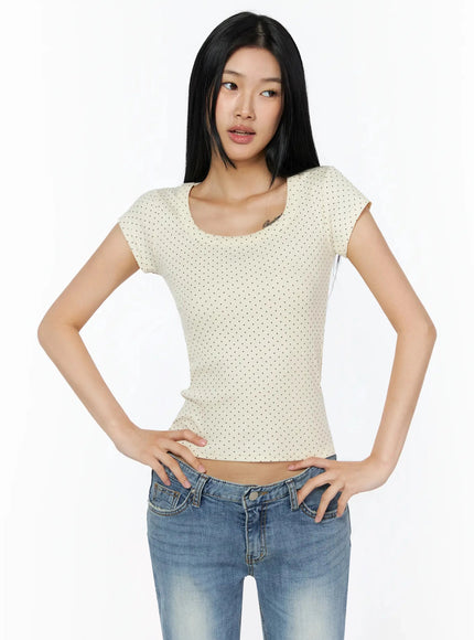 Square Neck Polka Dot Slim Tee IL509 Light beige half-body front shot model looking sideways hands on hips showing fitted body-hugging silhouette with jeans