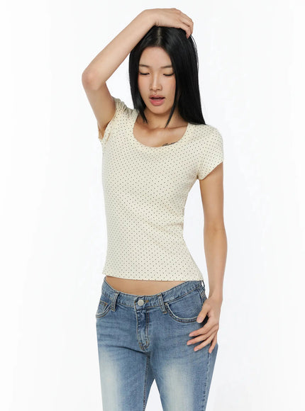 Square Neck Polka Dot Slim Tee IL509 Light beige half-body front shot model one arm raised overhead looking down showing cap sleeve and cropped hem detail