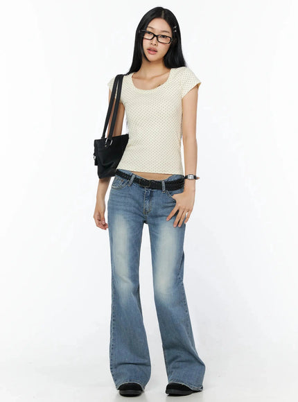 Square Neck Polka Dot Slim Tee IL509 Light beige full-body lifestyle shot model seated on chair arms crossed wearing glasses with braided belt and black bag