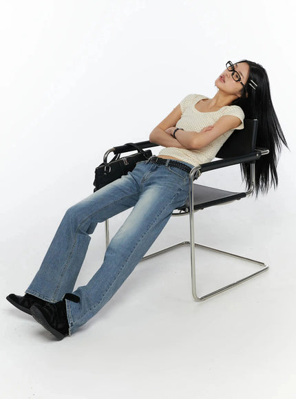 Square Neck Polka Dot Slim Tee IL509 Light beige lifestyle shot model reclining on black leather chair wearing glasses arms crossed relaxed pose