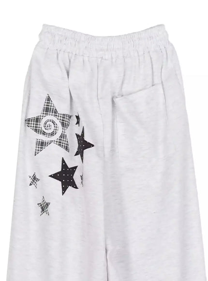 Star Graphic Wide Leg Sweatpants IL506 White flat-lay close-up showing elastic waist and black plaid and polka-dot star appliqués on thigh