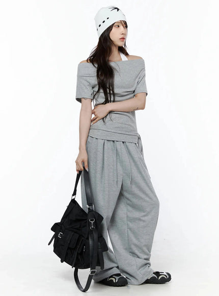 Star Graphic Wide Leg Sweatpants IL506 Gray lifestyle shot on model with beanie and black bag standing front three-quarter view