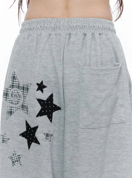 Star Graphic Wide Leg Sweatpants IL506 Gray close-up detail of mixed plaid and polka-dot star appliqués with back patch pocket and elastic waistband