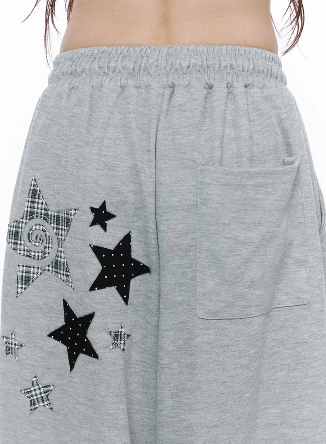 Star Graphic Wide Leg Sweatpants IL506 Gray close-up detail of mixed plaid and polka-dot star appliqués with back patch pocket and elastic waistband