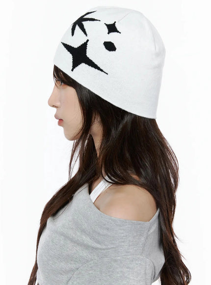 Star Knit Beanie IL506 White side on-model close-up, female model profile facing left, black starburst and four-point star intarsia knit pattern on white beanie