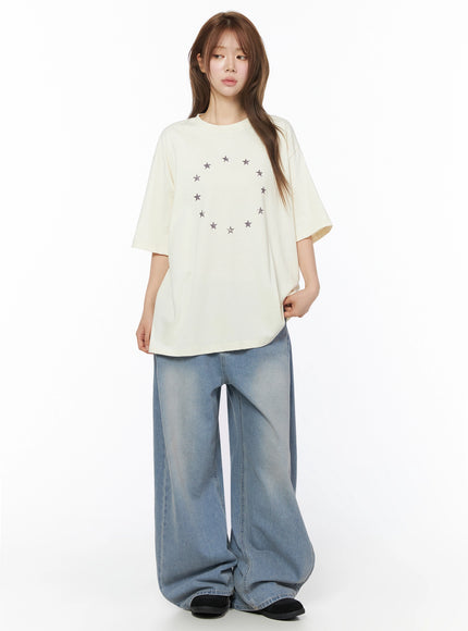 Star Ring Graphic Oversized Tee IL502 Light beige full-body front shot model standing upright circular star ring graphic oversized fit with wide-leg denim