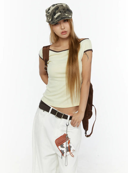 Staria vintage Cap IL503 camouflage full-body front shot on model styled with cream top, white trousers, brown belt and backpack