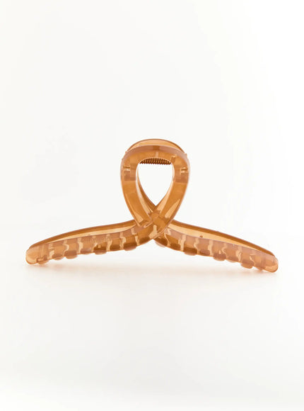 Stella Litter Hair Clip IL503 brown front view flat surface shot displaying crossed-loop top design with serrated claw teeth in translucent amber resin