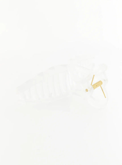 Stella Litter Hair Clip IL503 clear side flat-lay shot showing transparent elongated ribbed claw body with gold coil spring hinge detail on white background