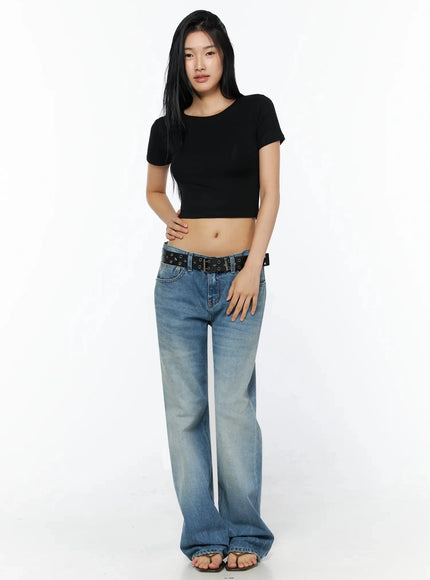Stretch Crop Tee IL509 Black full-body front shot on model standing relaxed one hand on hip styled with wide-leg faded blue jeans and star eyelet belt