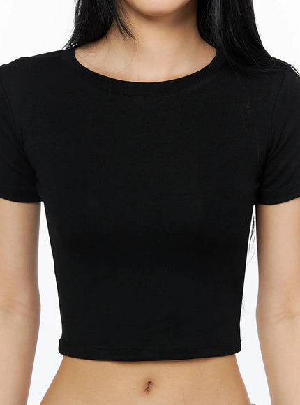 Stretch Crop Tee IL509 Black close-up front detail shot on model showing round neckline short sleeves fitted stretch cotton crop length and midriff