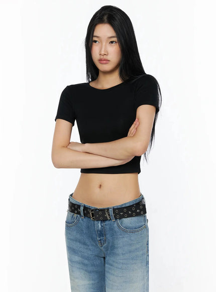 Stretch Crop Tee IL509 Black front shot on model arms crossed over chest showing fitted stretch fabric crop hem and round neckline with blue jeans