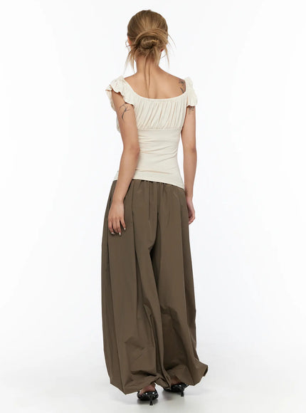 String Detail Parachute Pants CU524 Brown back full-length shot on model with cream top showing wide-leg drape and pooled hem