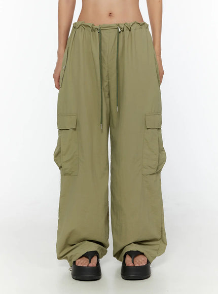 String Pocket Wide Pants CU526 Dark green front shot on model showing drawstring waist, dual cargo pockets, wide-leg nylon silhouette and black platform sandals