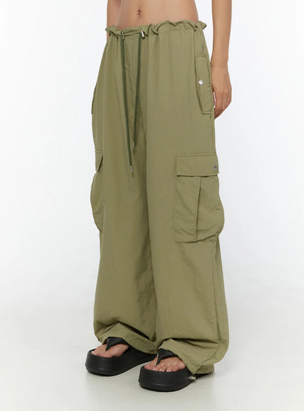 LEWKIN String Pocket Wide Pants CU526 Dark green side shot on model showing cargo pockets, drawstring waist, wide-leg silhouette, nylon fabric