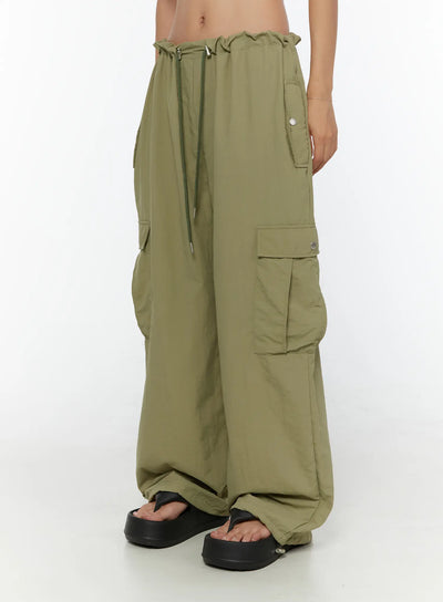 LEWKIN String Pocket Wide Pants CU526 Dark green side shot on model showing cargo pockets, drawstring waist, wide-leg silhouette, nylon fabric