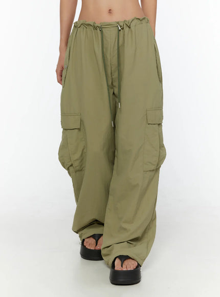 String Pocket Wide Pants CU526 Dark green front shot on model showing drawstring elastic waistband, dual cargo pockets and wide-leg nylon trousers