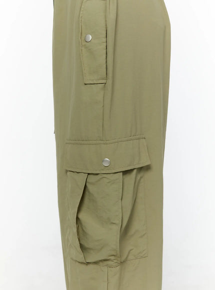 String Pocket Wide Pants CU526 Dark green close-up detail of side snap-button cargo pockets showing upper slant pocket and lower flap pocket with silver snap hardware