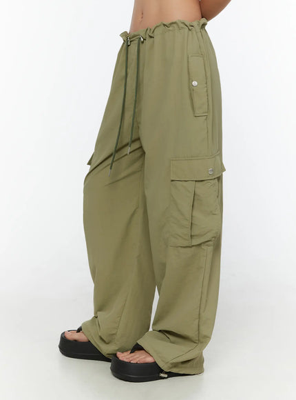 String Pocket Wide Pants CU526 Dark green side shot on model highlighting snap-button cargo pockets, drawstring waist and oversized wide-leg fit