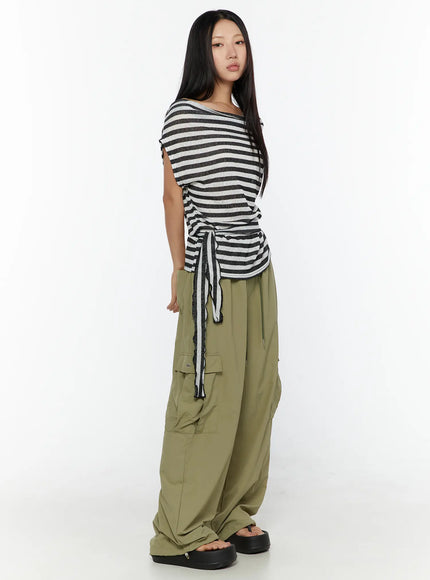 String Pocket Wide Pants CU526 Dark green full-body side shot on model in striped top showing voluminous wide-leg silhouette and gathered hem pooling at platform sandals