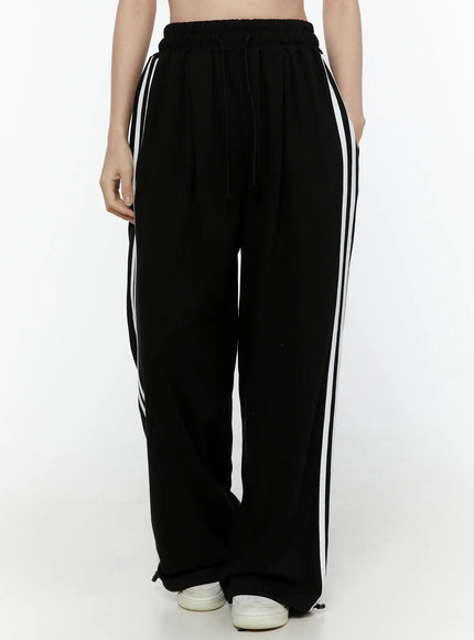 Stripe Detail Sweatpants IL506 Black front waist-to-hem model shot, elastic waistband with drawstring and white side stripe detail visible on wide-leg pants