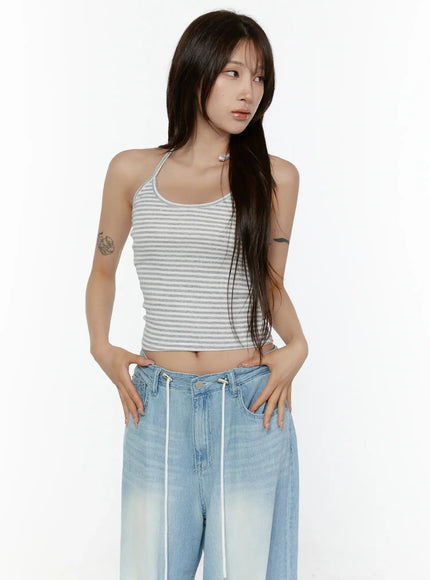 Stripe Halter Sleeveless Top CL507 Gray three-quarter front shot on model in S/M hands on waist showing cropped length striped ribbed knit halter neck detail