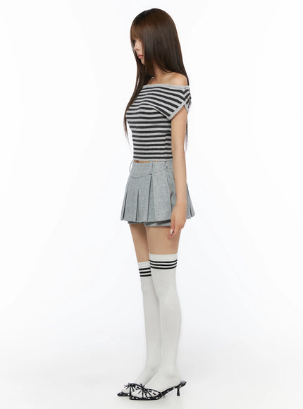 Stripe Off-Shoulder Knit Top IL506 Gray side view on model showing off-shoulder silhouette and cropped length, paired with gray pleated mini skirt and white striped knee-high socks