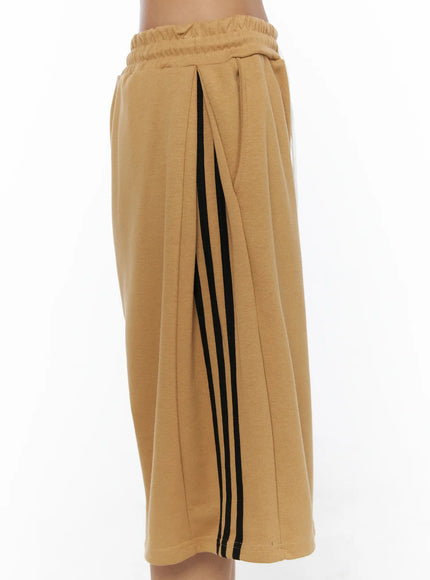 Striped Bermuda Shorts CL503 Beige close-up side detail showing triple black stripe, pleated side panel, elastic waistband and soft heavyweight cotton-blend texture