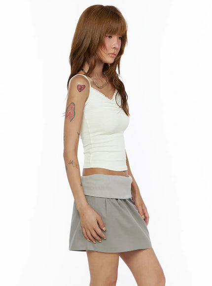 Striped Cami Top CL503 White side model shot, off-white ribbed stripe cami with lace trim and center ruche detail, styled with gray mini skirt and chain necklace