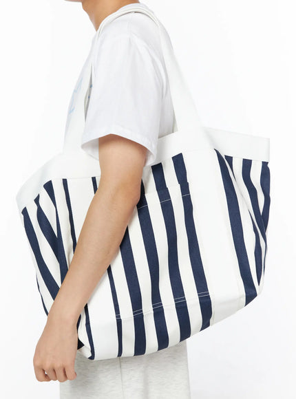 LEWKIN Striped Canvas Tote Bag IL514 Dark blue side shot on model wearing white tee and grey shorts, large navy stripe canvas tote carried on shoulder
