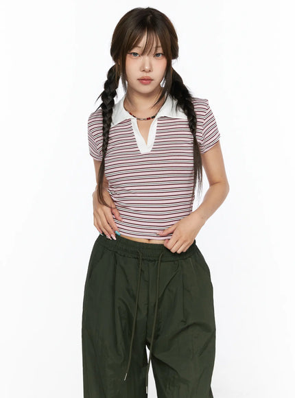 Striped Collared Crop Top Tee CL514 Pink front shot on model with twin braids looking forward, hands at hem showing cropped length and fitted stretch stripe body