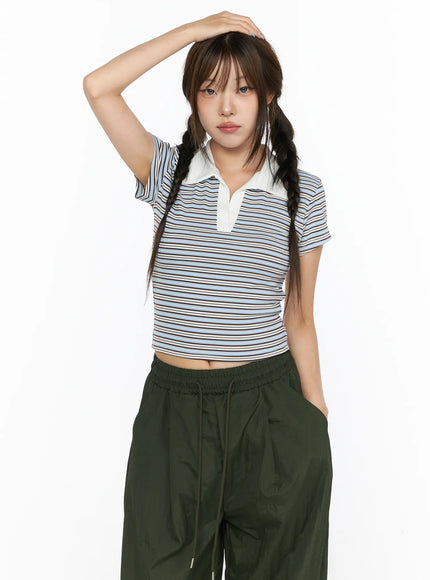 Striped Collared Crop Top Tee CL514 Blue front shot on model with hand raised to head, white polo collar, paired with dark green wide-leg pants